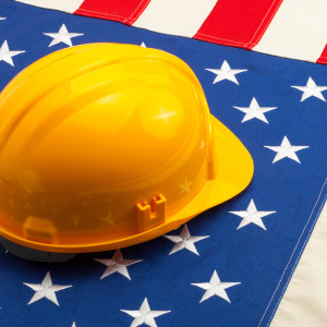 Construction helmet laying over USA flag - construction industry concept