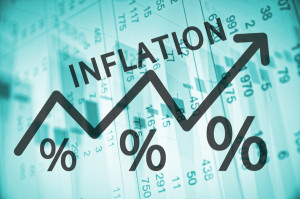 Word Inflation on up trend arrow, with financial data visible on the background.